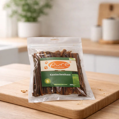 PURE Kaninchenhaut Hundesnack auf Holzbrett, schonend getrockneter Naturkauartikel